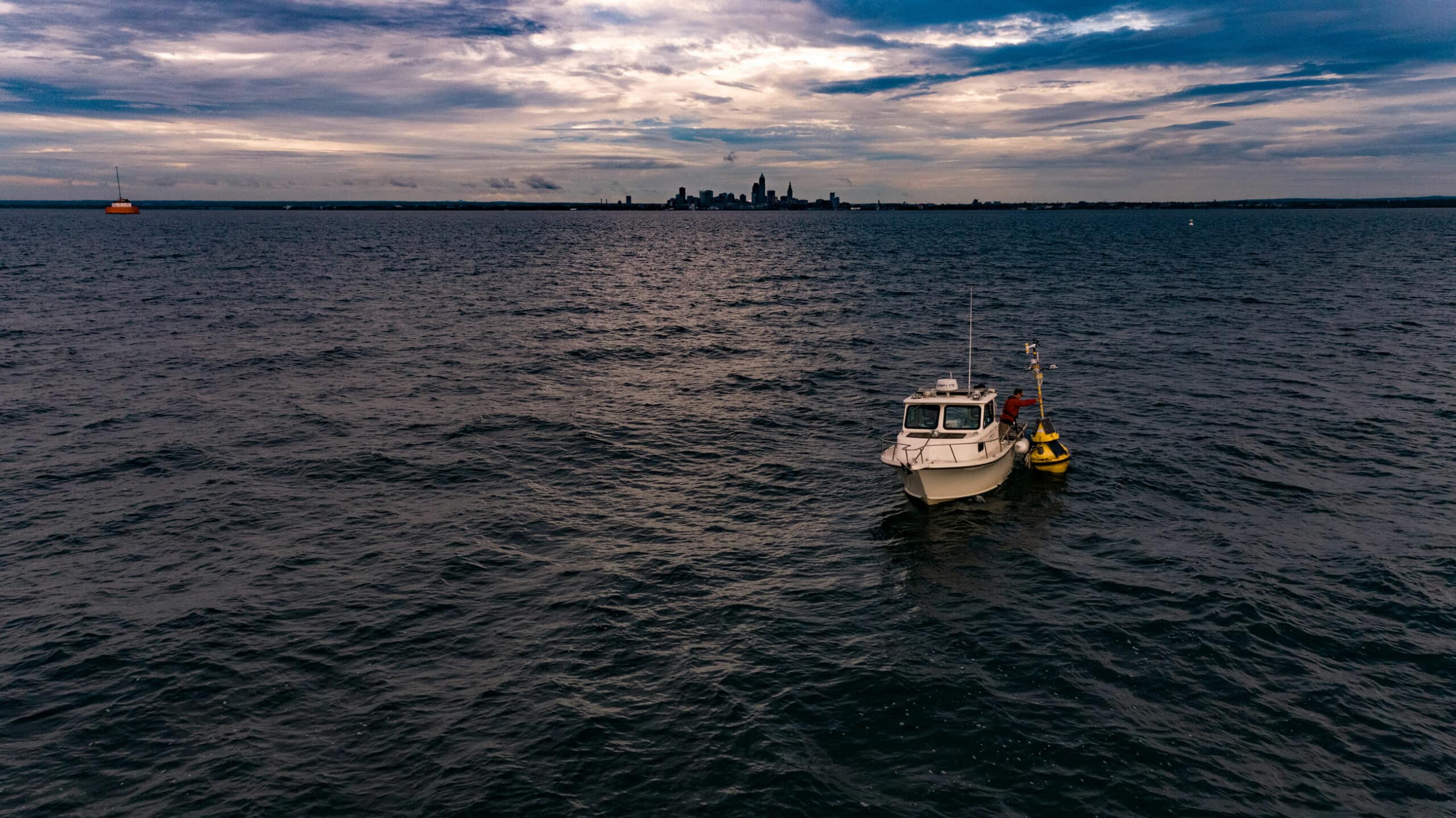Freeboard technician deploying smart buoy in Lake Erie near Cleveland, Ohio to monitor water quality.